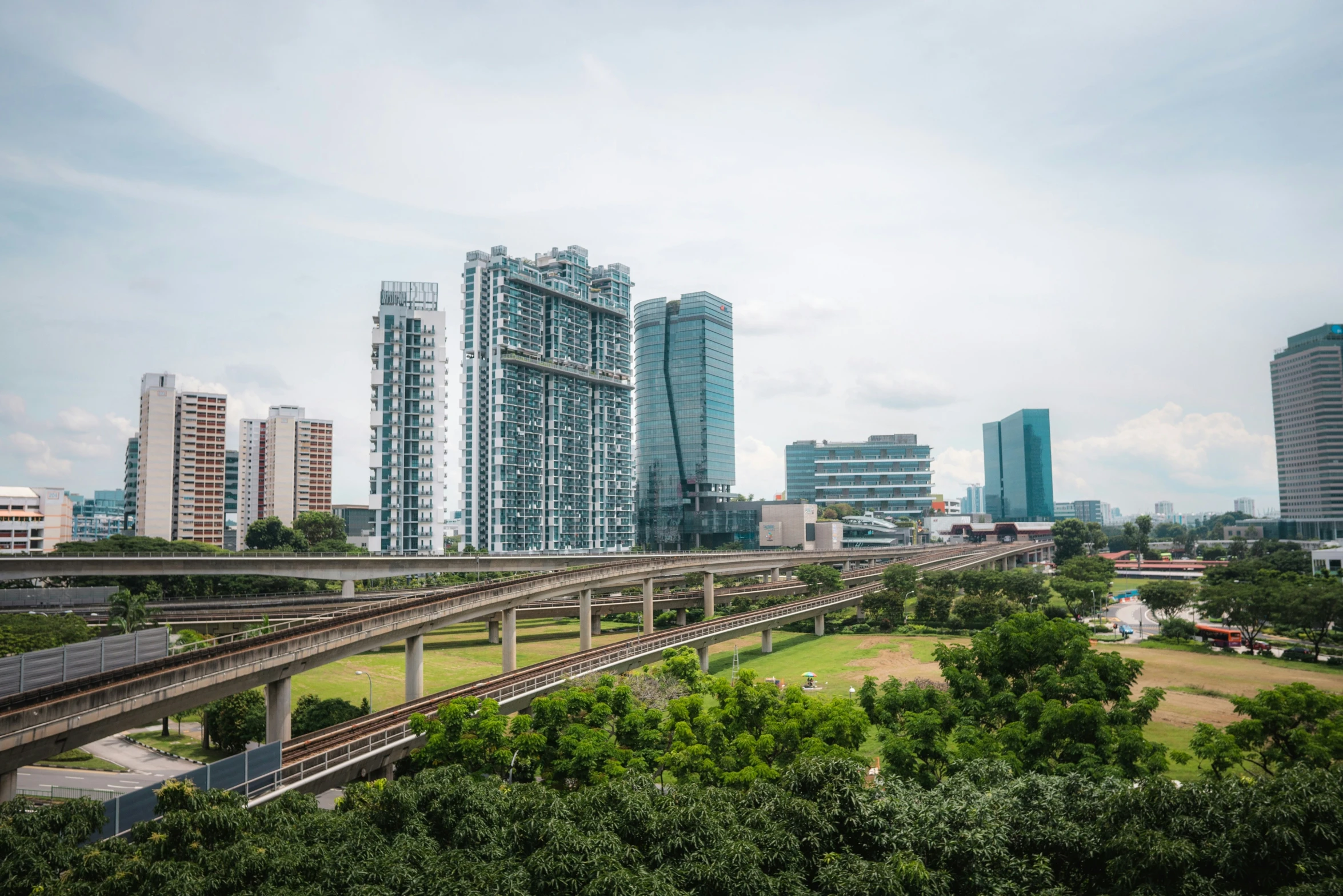 a train tracks near a city with high rise buildings