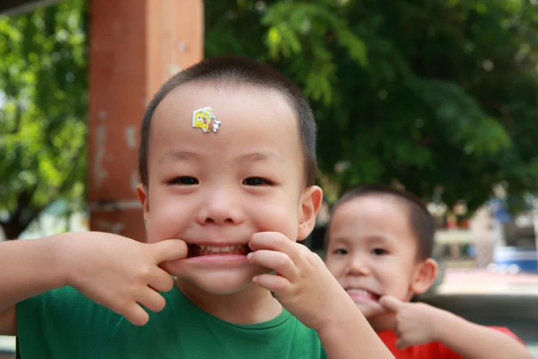 the boys are playing outside together with the stickers on their mouths