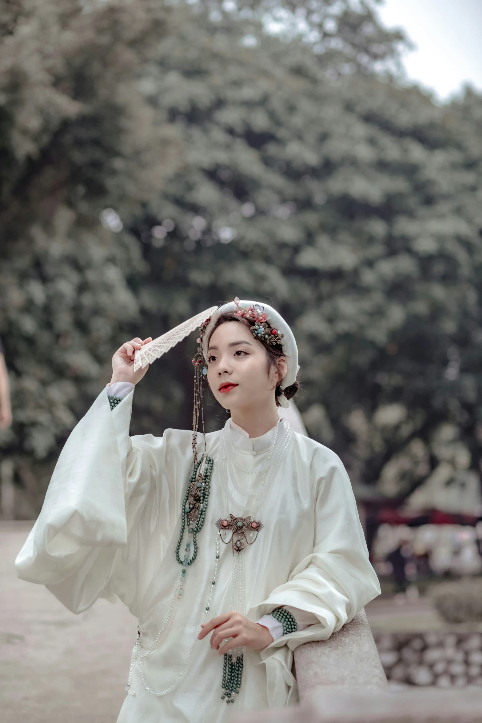 an asian lady wearing a white outfit standing