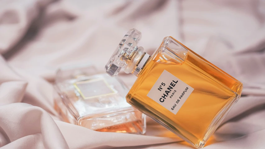 two bottles of chanel perfumes on the bed