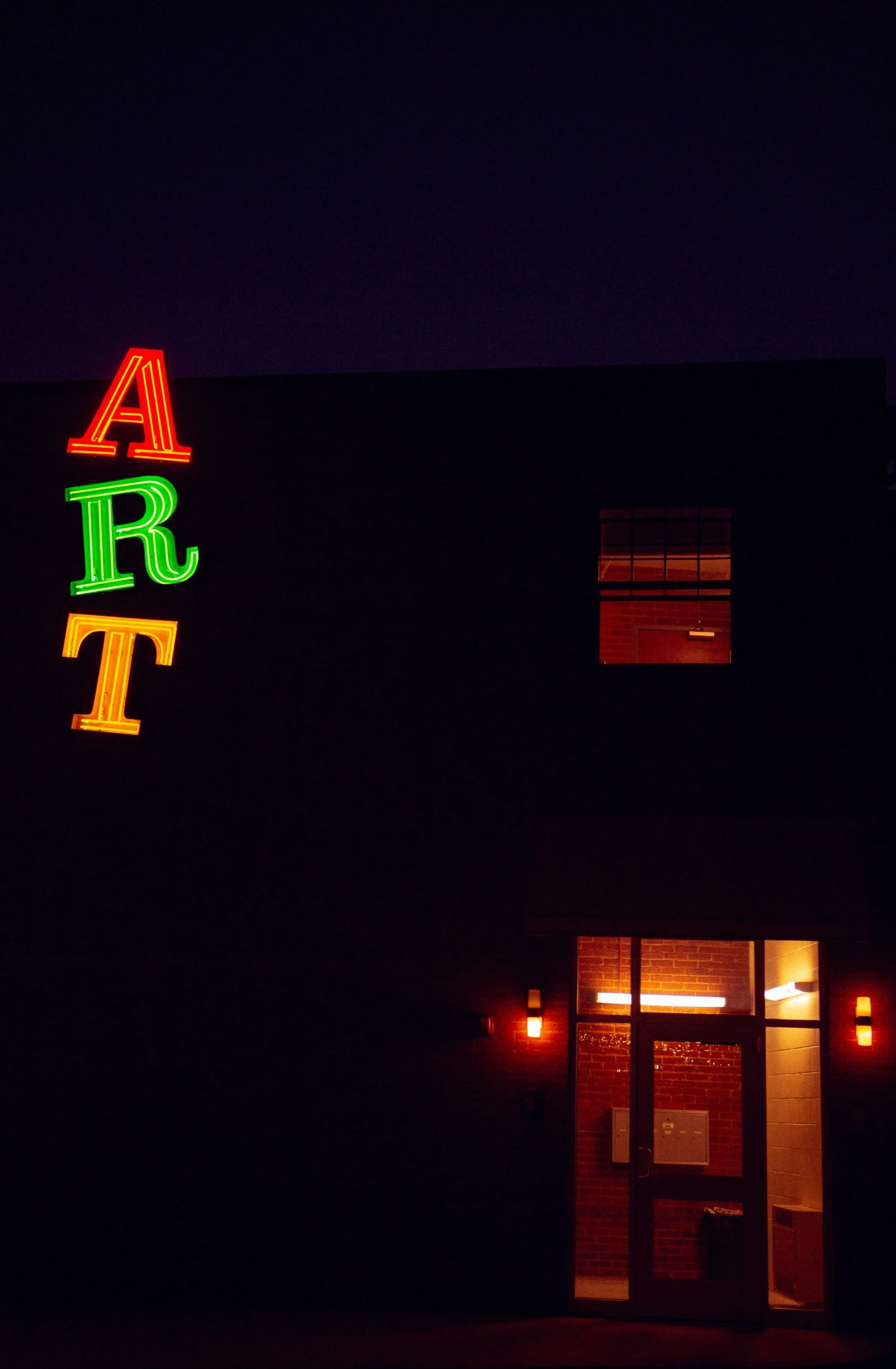 a building with a lighted sign outside at night