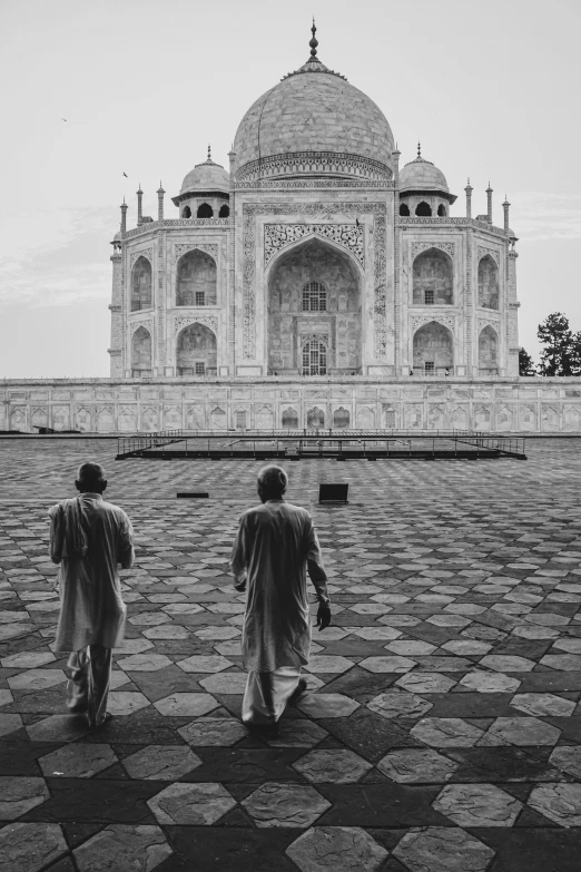 two people walking in front of the tajr at the top of the tajr