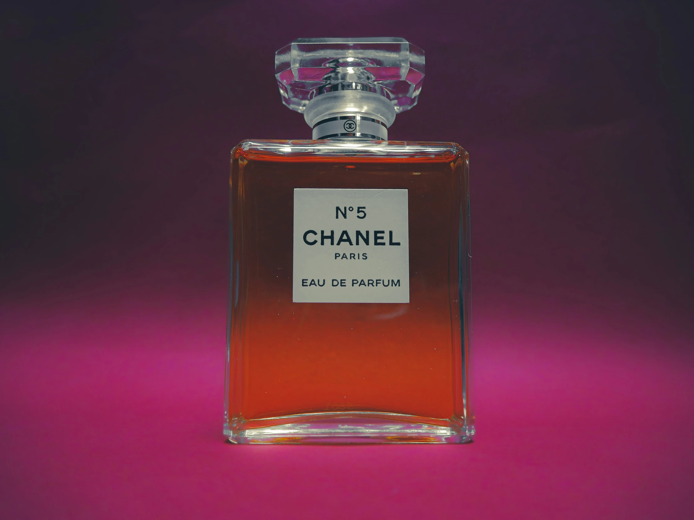 there is a bottle of chanel perfume on a pink background