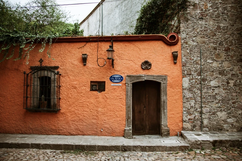 an orange building with doors on one side and windows on another