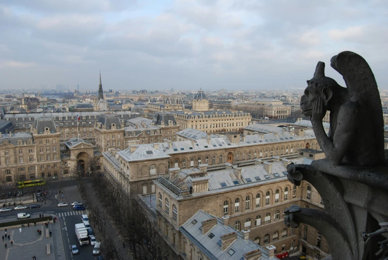 a statue on top of the roof looking at a city