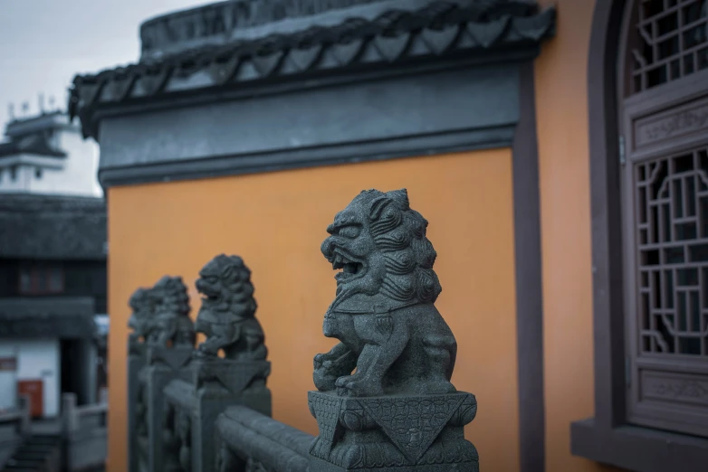 a fence with lions on it in front of a building