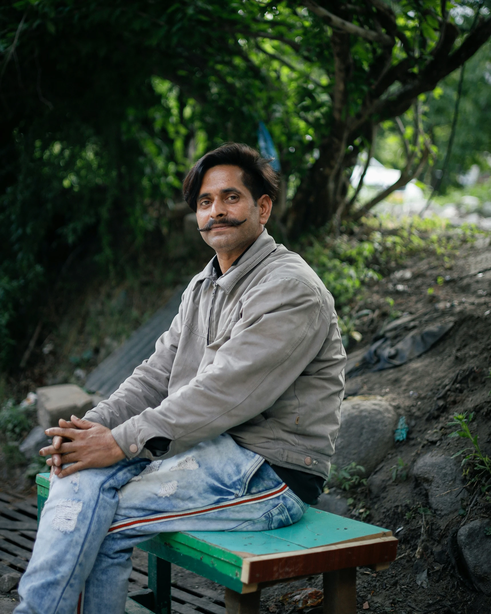 man sitting on wooden bench by muddy water