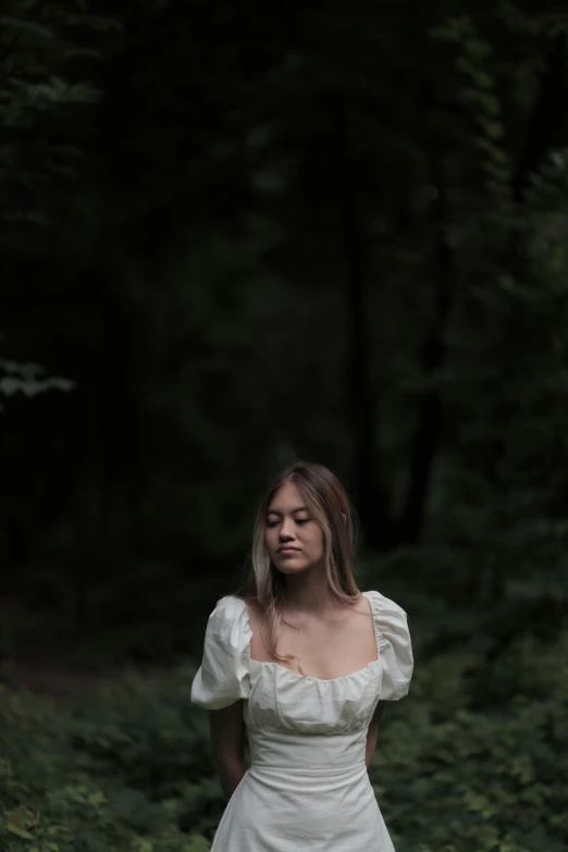 a woman in a wedding dress standing outside