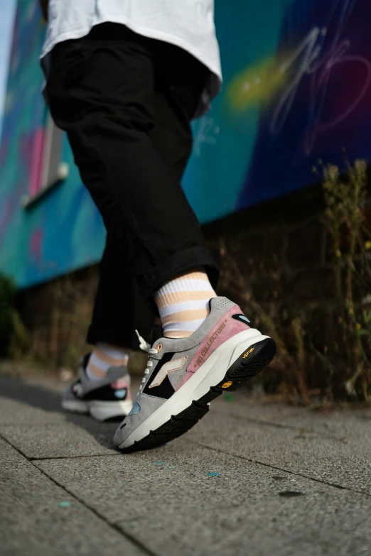 a person is standing on a sidewalk wearing white socks and sneakers