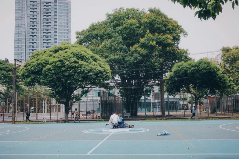 two people sitting on a basketball court next to each other