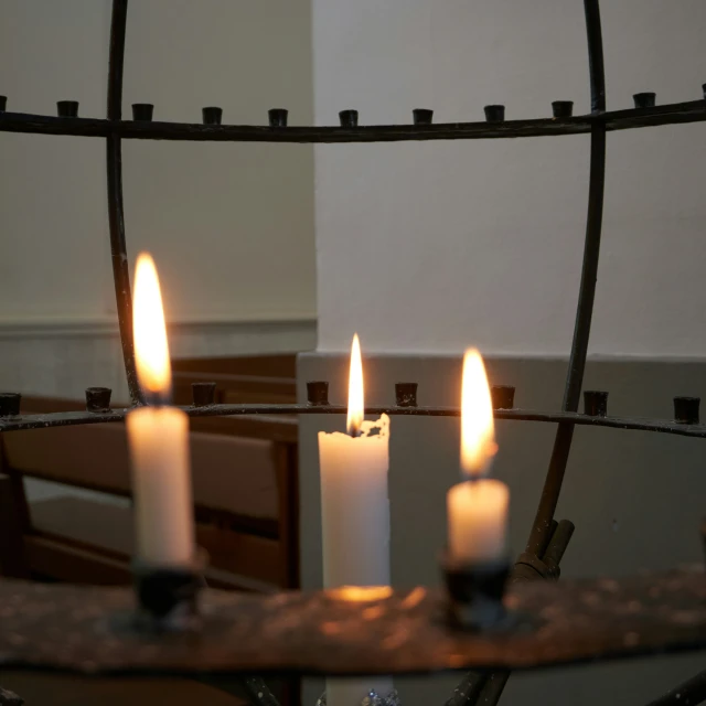 two white candles are in the center of a chandelier