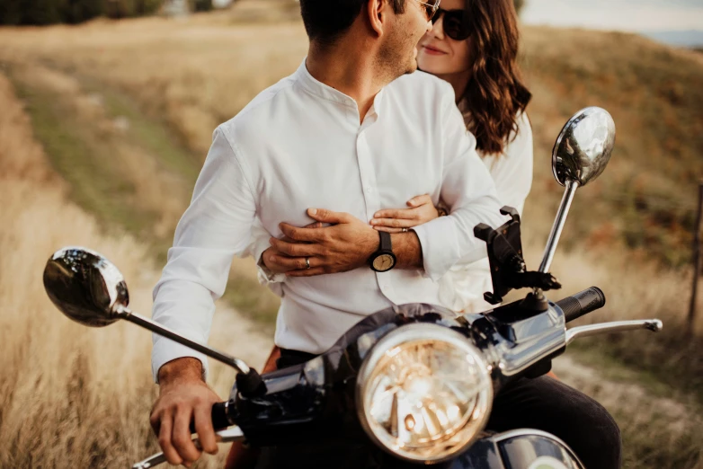 a man and a woman emcing on a motorcycle