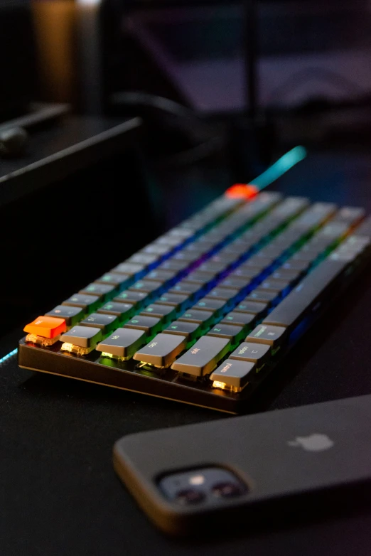 a yellow, green and blue keyboard sitting on top of a black desk