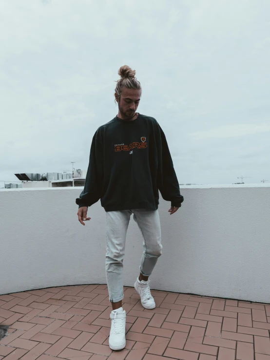 a man wearing a sweatshirt and shoes posing for the camera