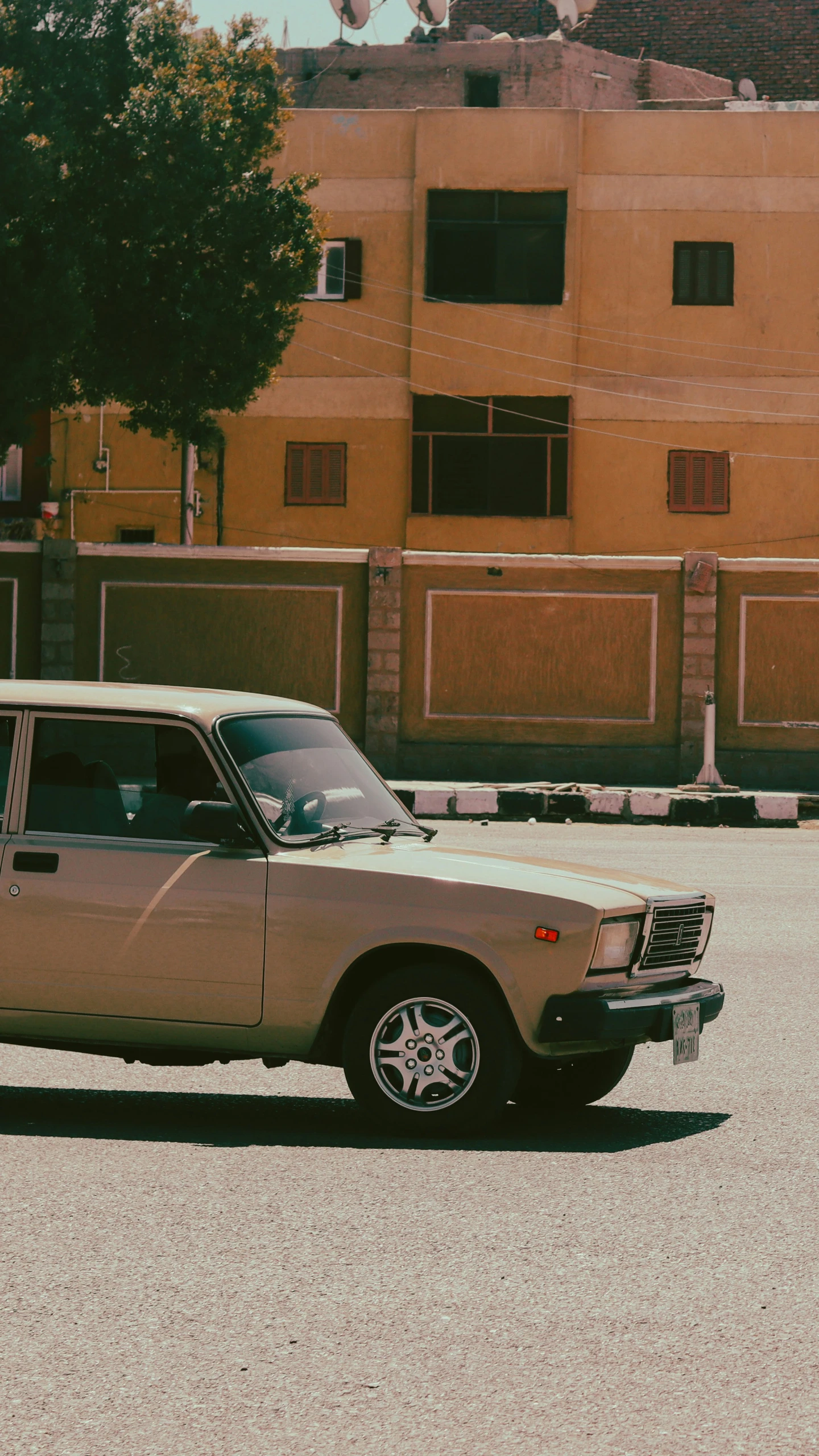 a car parked outside of a brown building