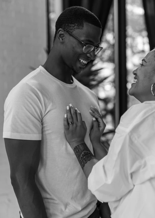 a couple laugh together while standing in front of a building