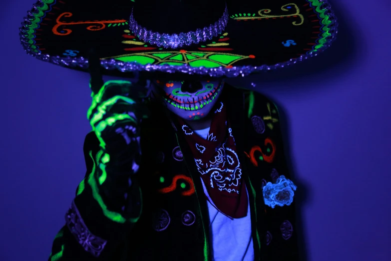 mexican wrestler wearing colorful outfit and sombrero while holding cell phone