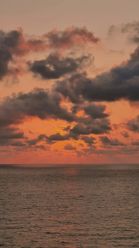 a view of the water under a sunset with clouds