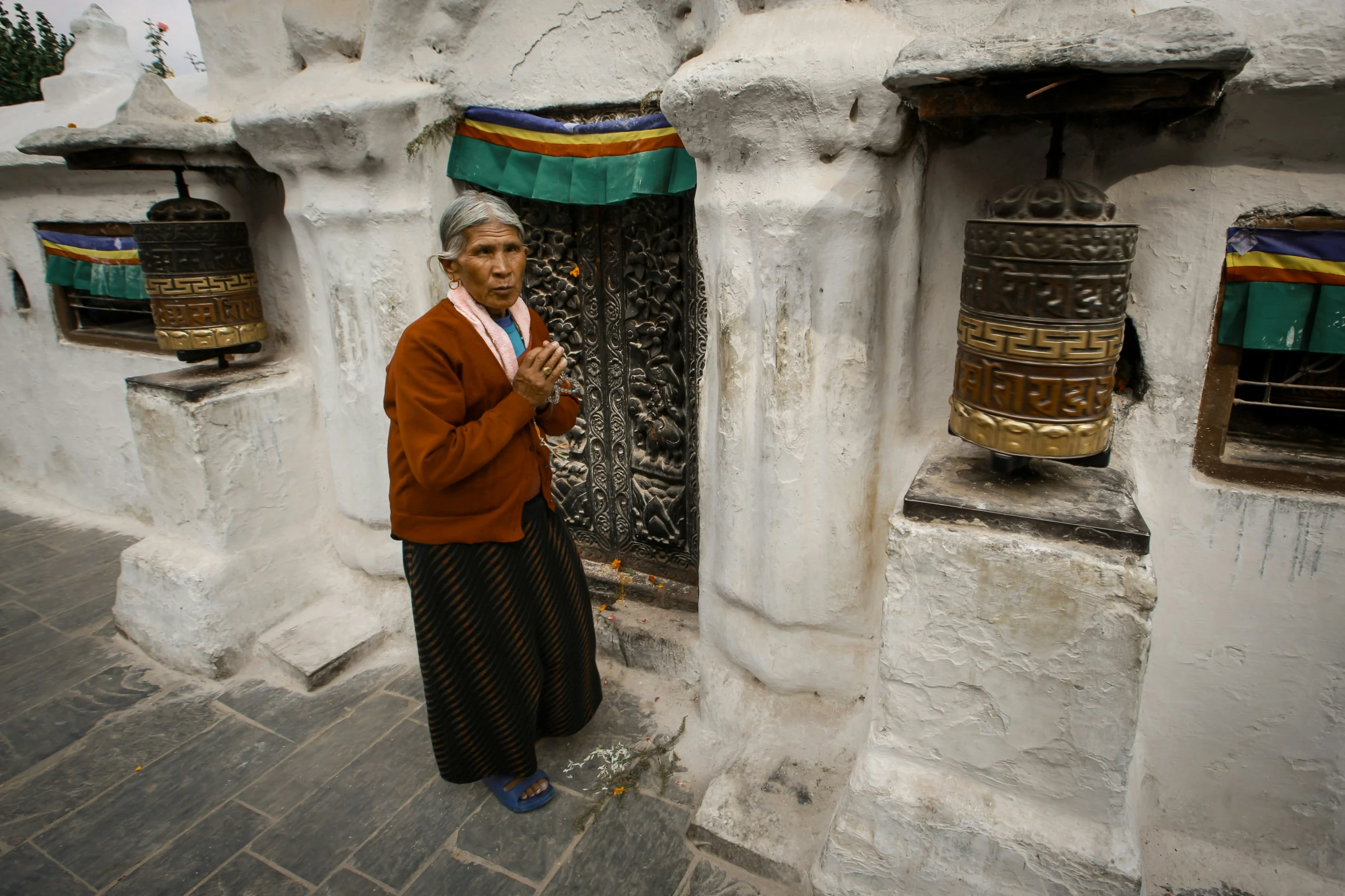 a woman stands near the entrance of a rock and cement structure