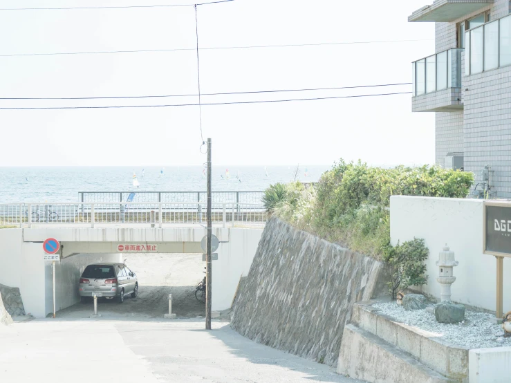 there is a sign near a wall by the ocean