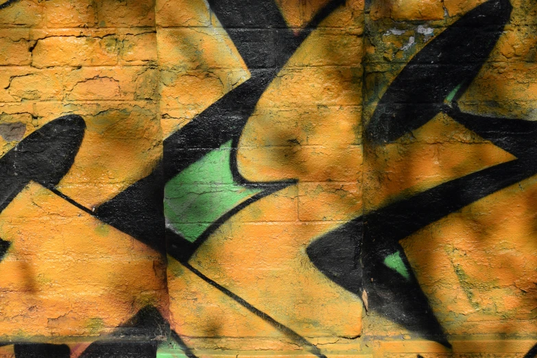 a yellow brick wall that has been decorated with graffiti