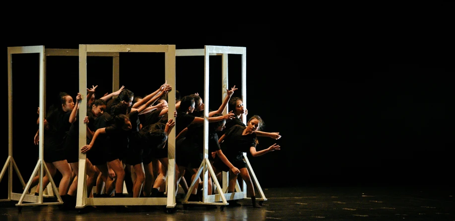 people are performing in front of a wooden structure