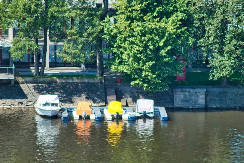 four boats are on the water in front of some houses