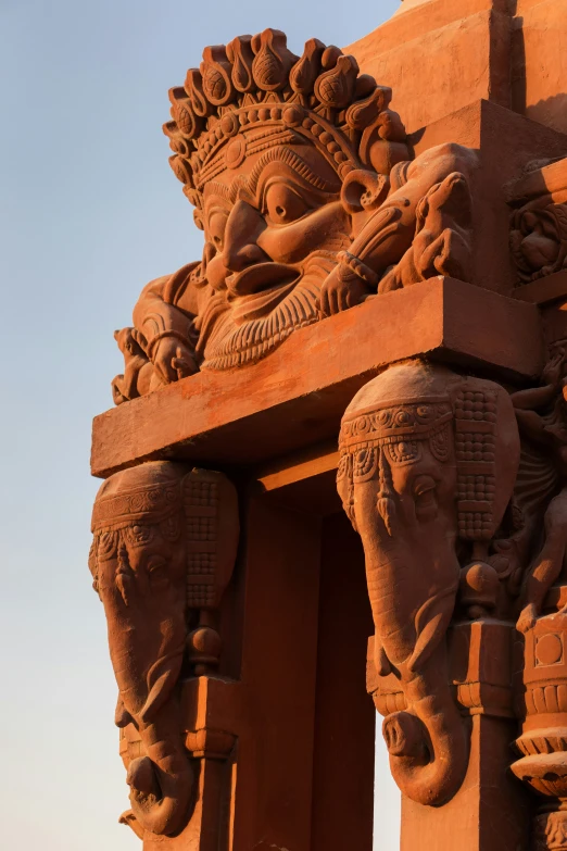 sculptures on top of a stone structure with sky in background