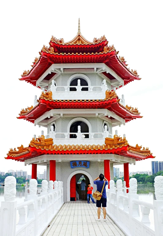 two men are standing outside a red and white pagoda