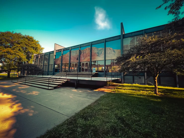 the building is made from glass with steps leading up to it