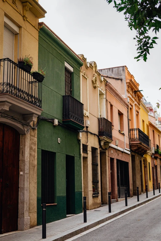 a row of multicolored residential buildings lining an empty street