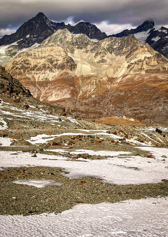 a large snow field that has some brown mountains in the background