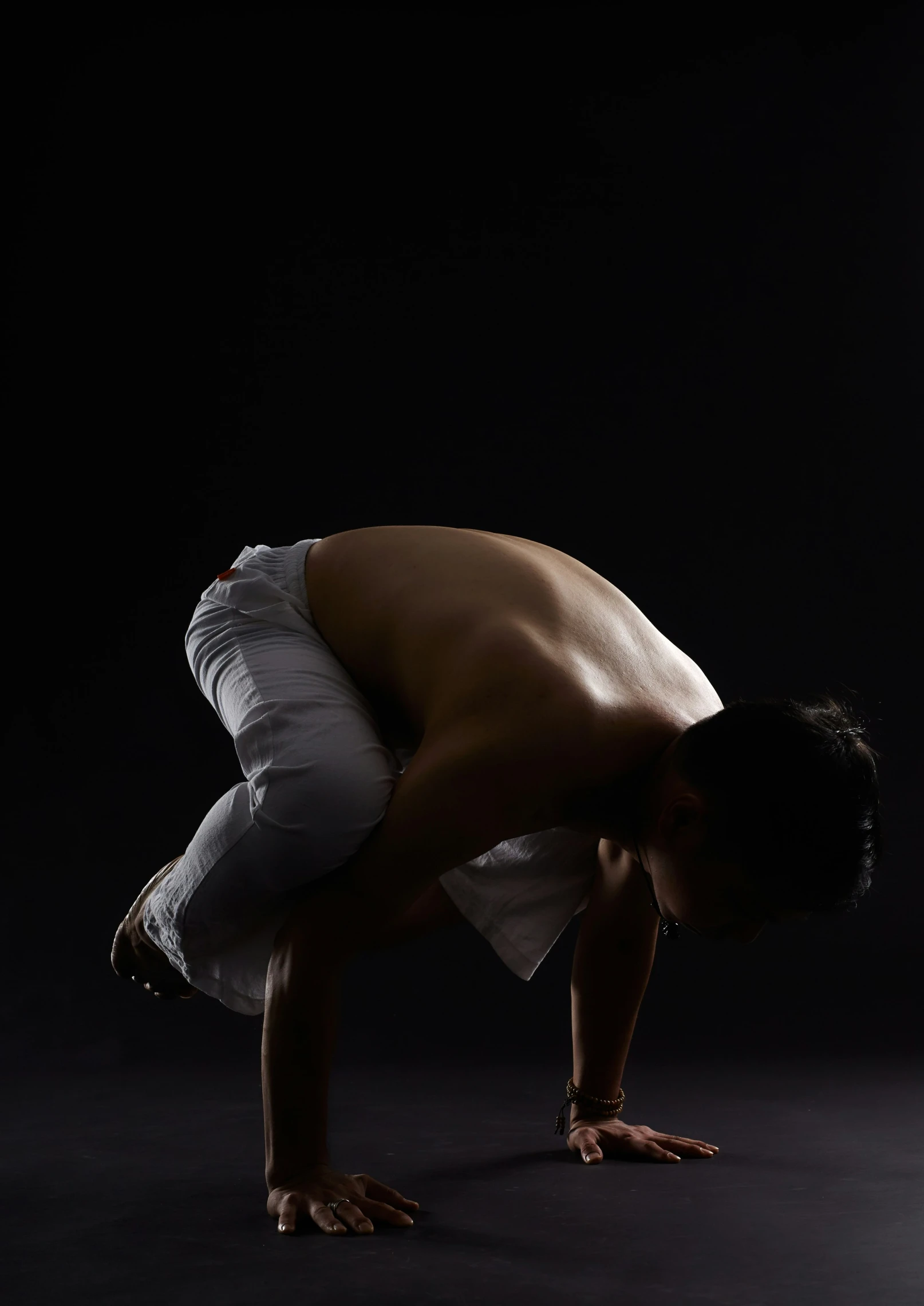 a man crouching down with his shirt tucked over his arms