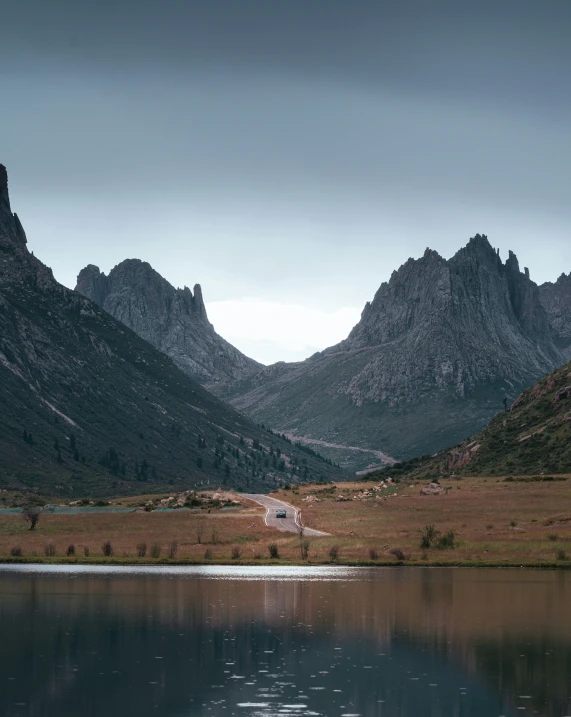 two mountain ranges surround a lake on a cloudy day