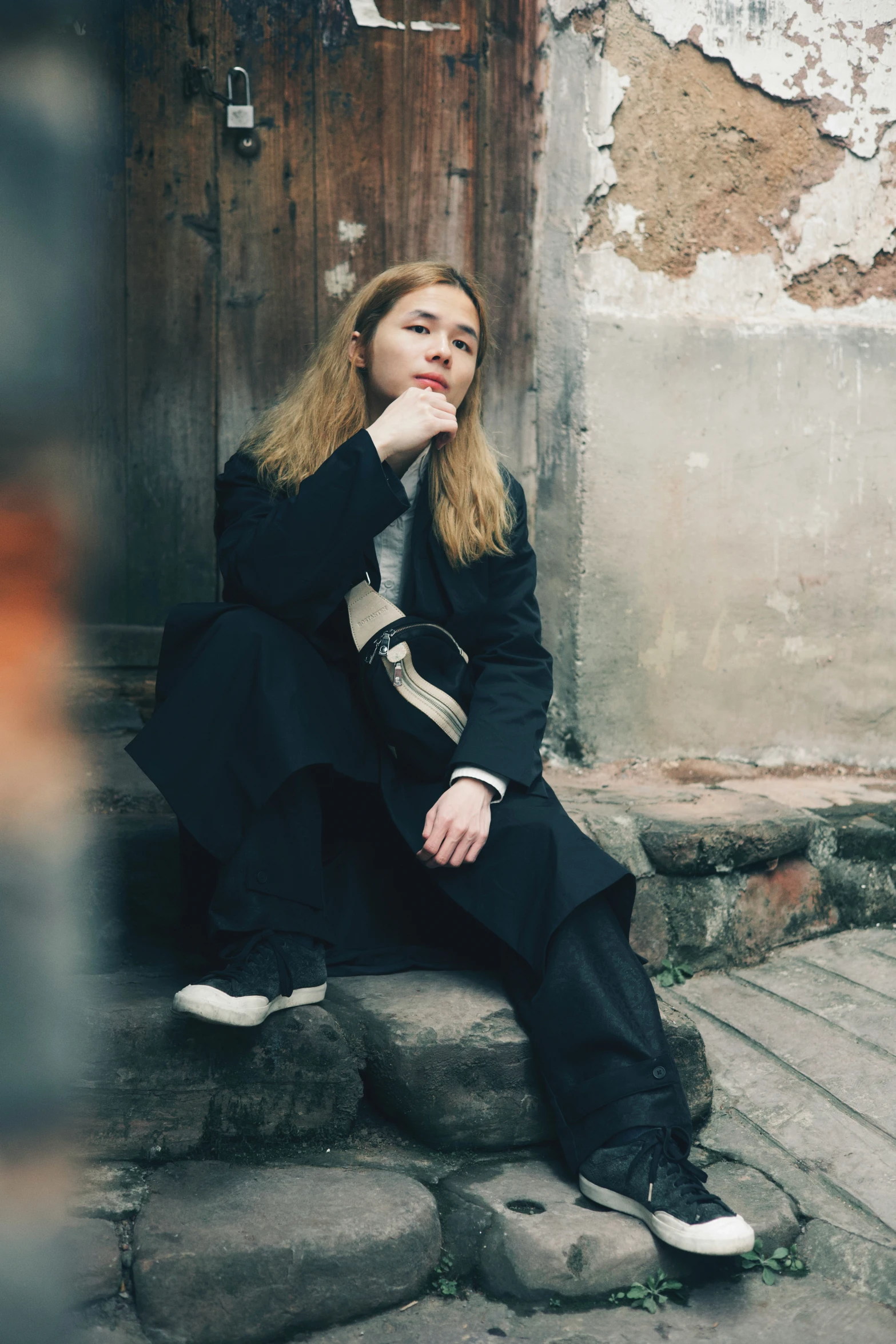 a person sitting on rocks looking up at soing