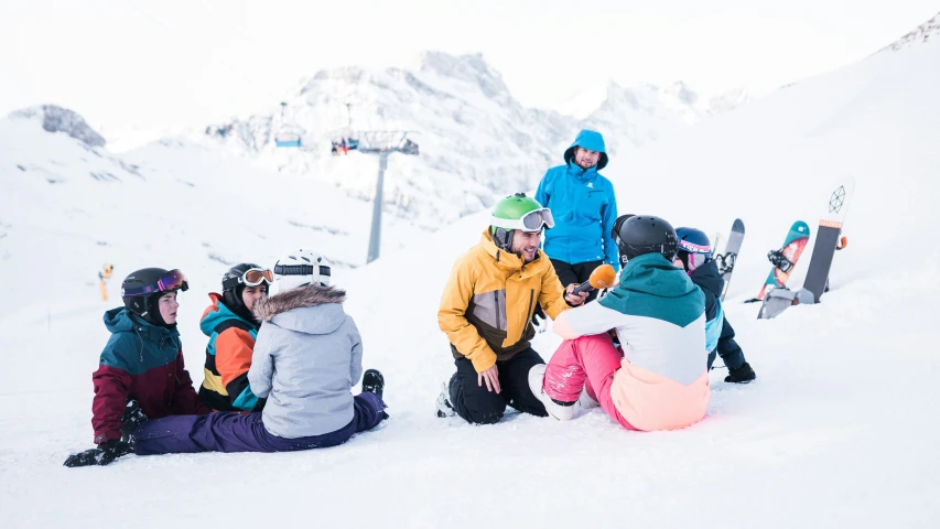 a group of children in snow gear at the bottom of a mountain