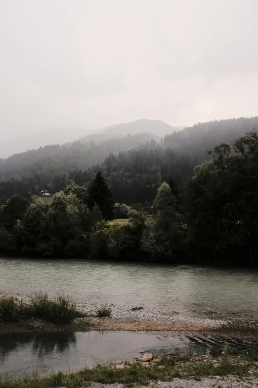 foggy morning by a river and green mountains