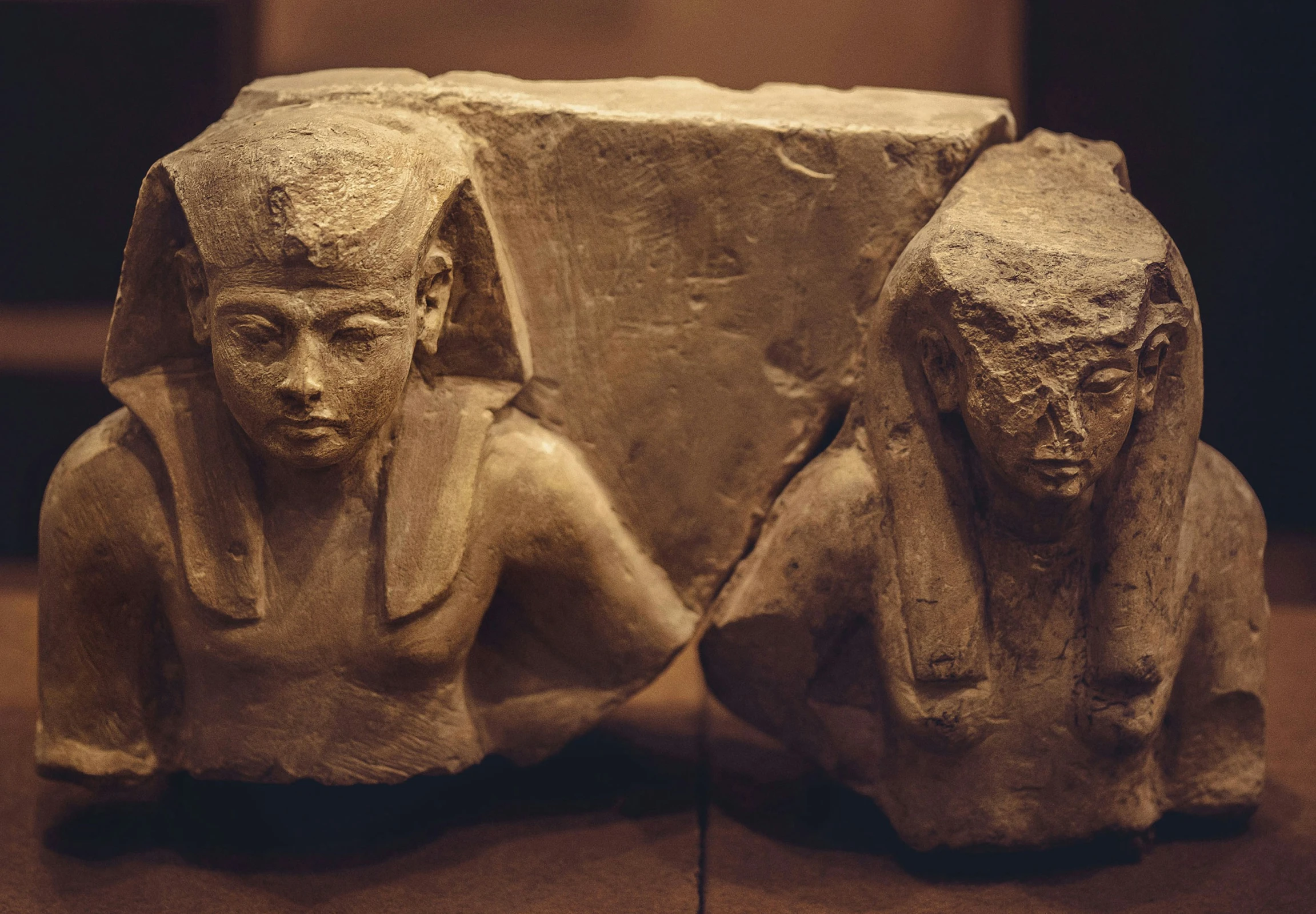 two ancient sculptures on display in a museum