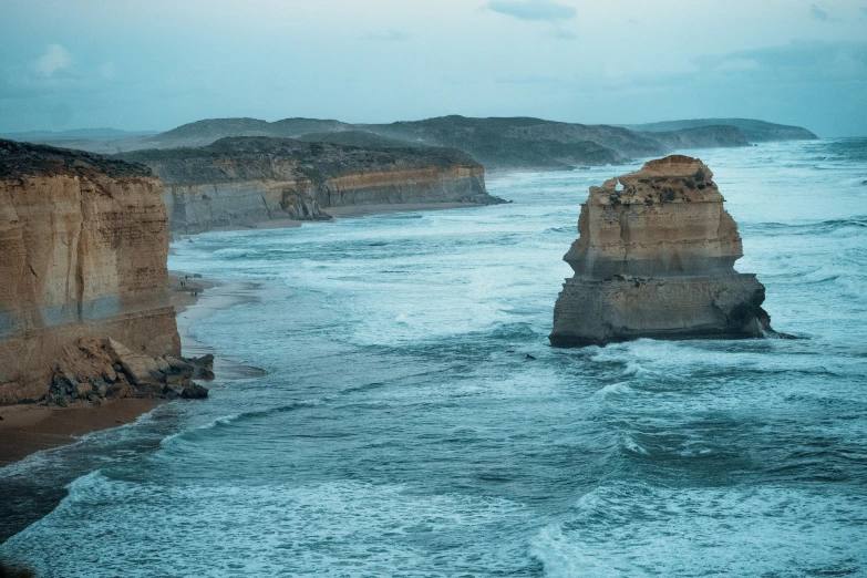 a large body of water with a large rock in the middle of it