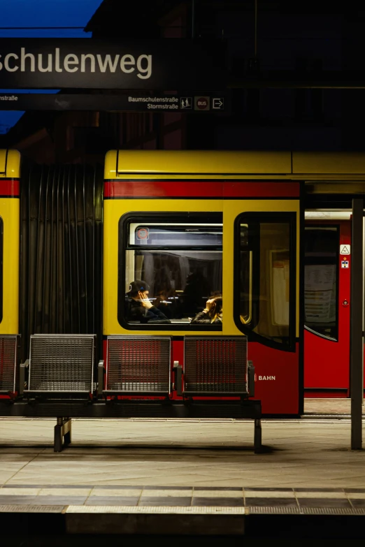 a train stopped in front of a loading area at night