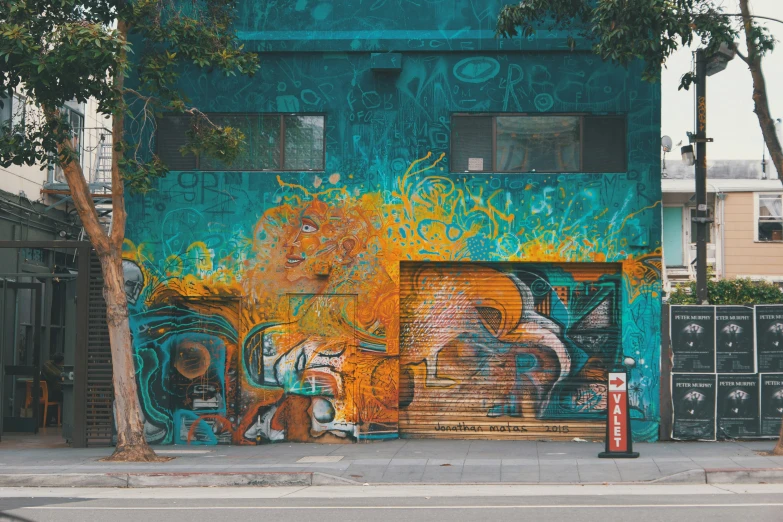 a building painted with a mural and street signs