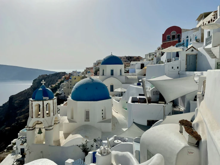 a small village with white and blue buildings and mountains