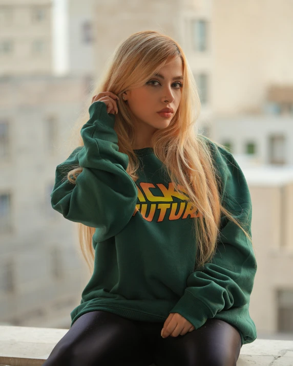 a pretty young blonde woman in a green sweatshirt