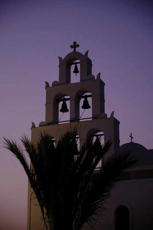 there is a church tower with bells on the top