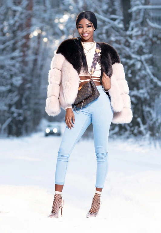 a woman standing in a snowy area wearing a jacket and jeans