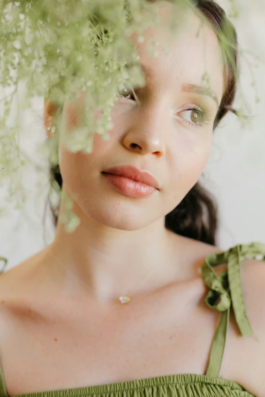 young woman in dress with flowers looking into camera