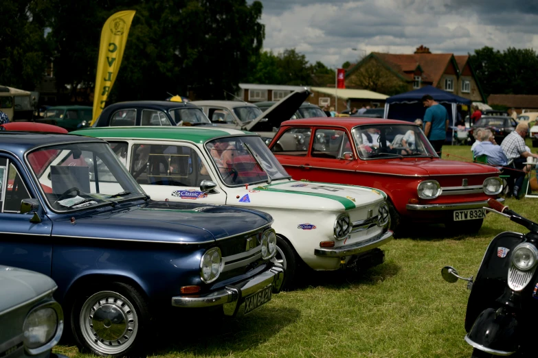 classic cars lined up in the grass at an automobile show