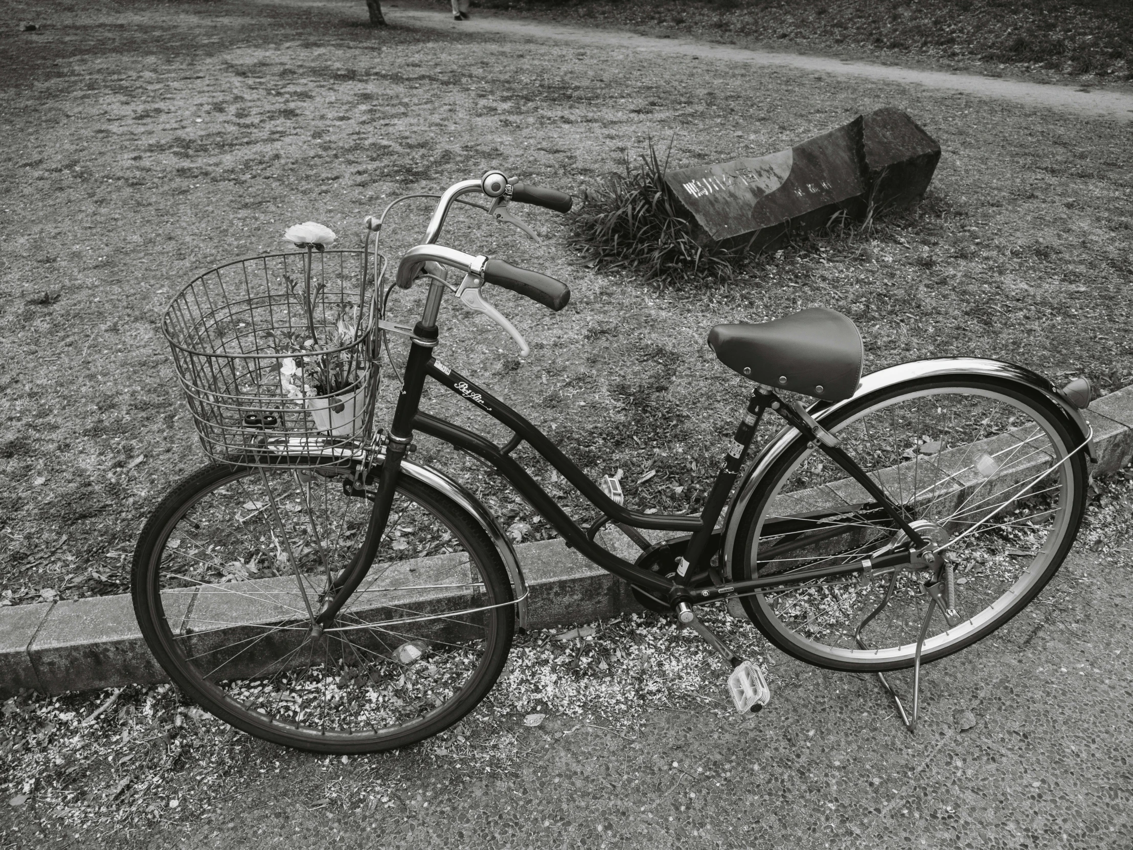 a bike parked next to a bench on the grass