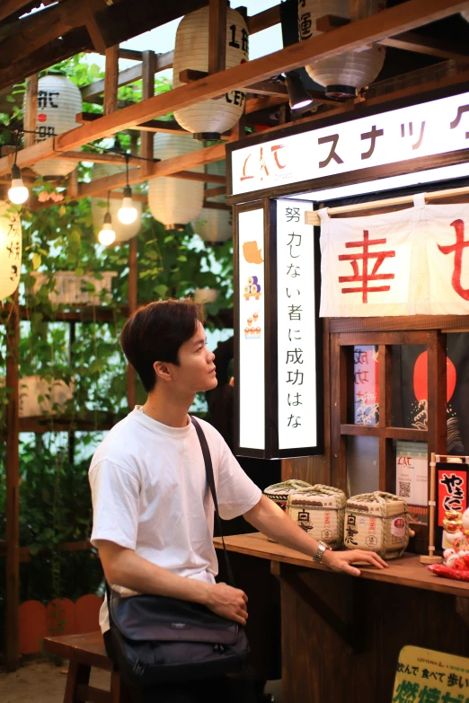 a person is sitting at a stand and has some food