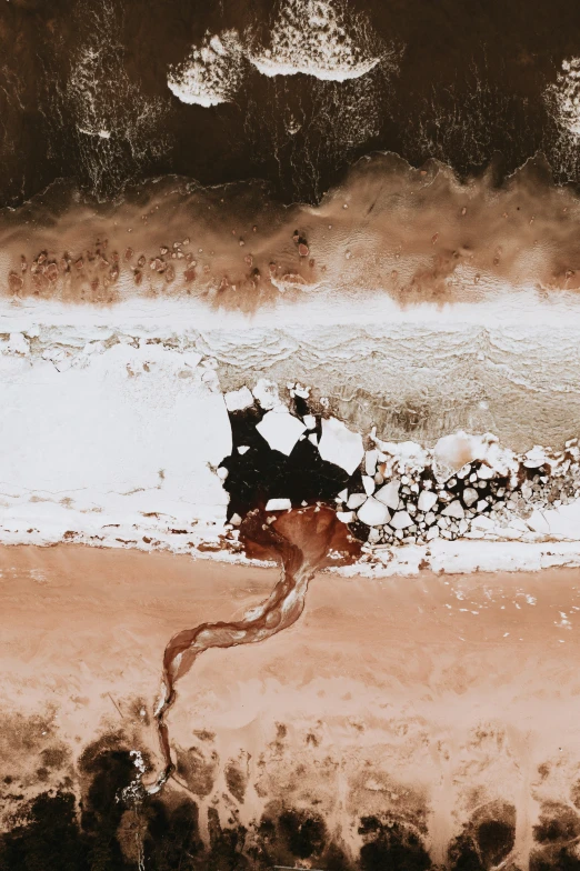 two people sitting on the beach together, near the ocean